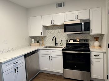 A kitchen with white cabinets and a black stove top oven.at Century Apartments, Tennessee, 38117